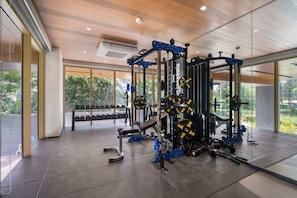 Ein modernes Fitnessstudio mit Krafttrainingsgeräten, großen Fenstern und einem aufgeräumten, großzügigen Raum.