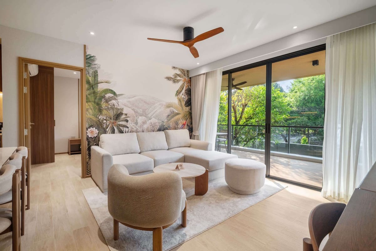 A modern living room with a sectional sofa, a round coffee table, and a ceiling fan.