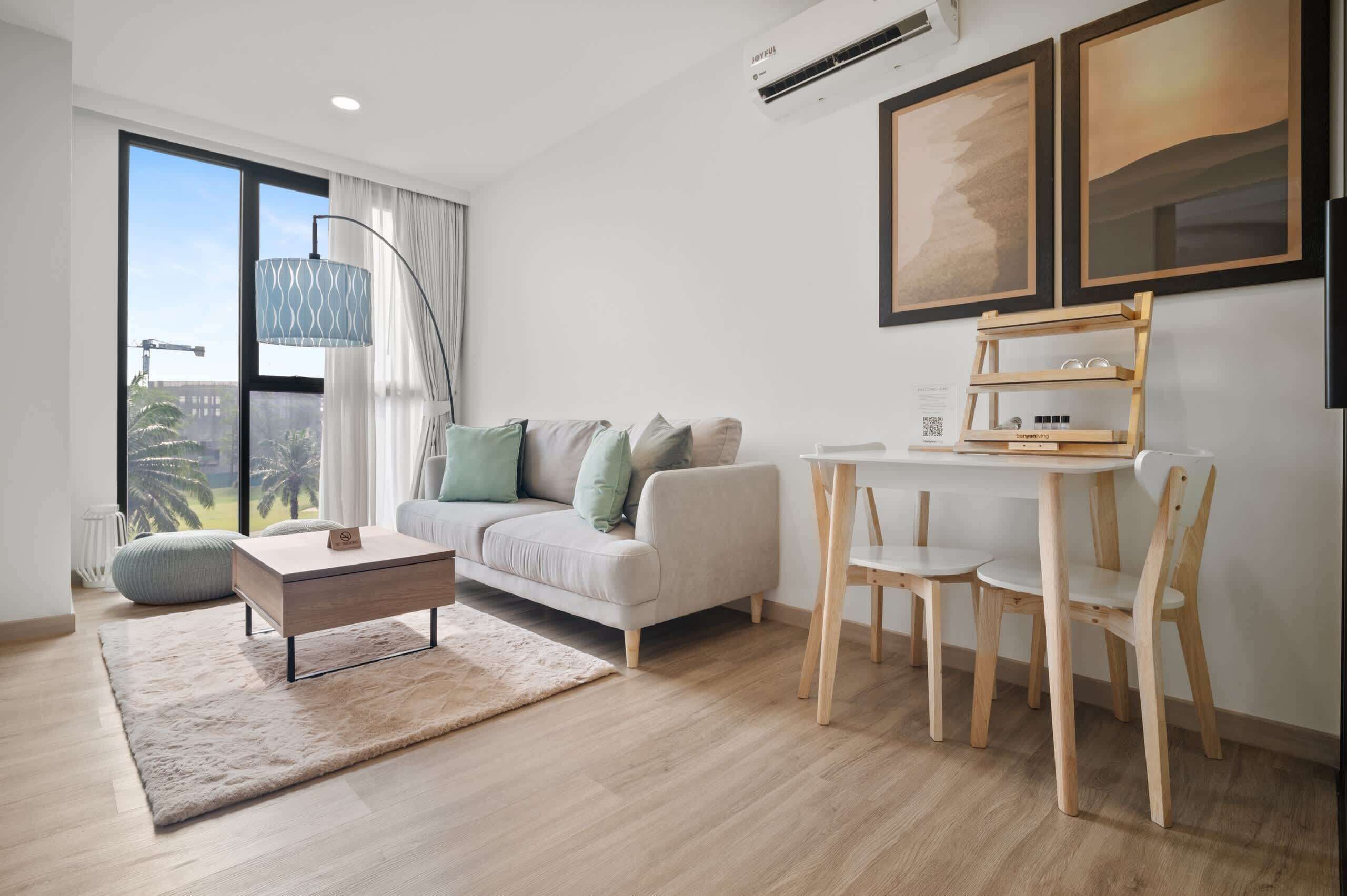 Una sala de estar moderna con sofá, mesa de centro y una mesa de comedor con sillas.