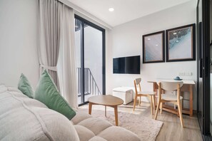 Ein modernes Wohnzimmer mit einer Couch, einem kleinen Tisch und einem Fernseher.