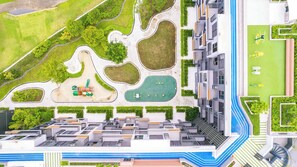 A modern residential complex with a central courtyard, surrounding greenery, and a multi-story building with balconies. - Skypark Aurora Building 3 in Laguna by Banyan Living (Choeng Thale)