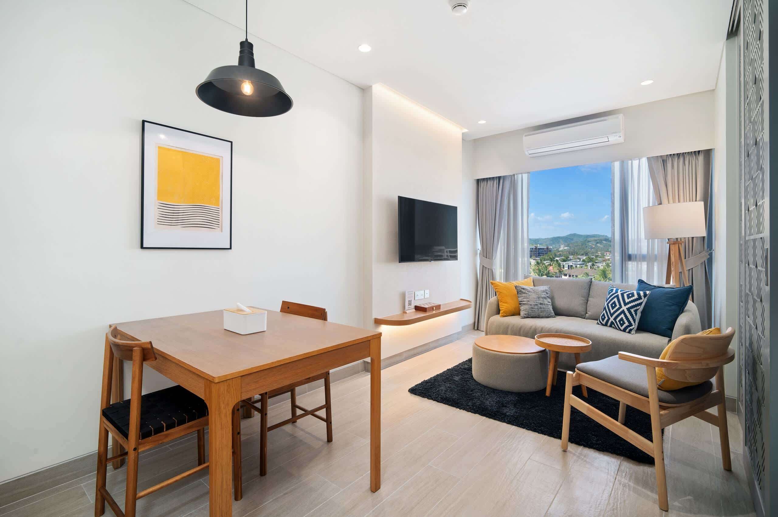 A modern living room with a dining table, sofa, and TV.