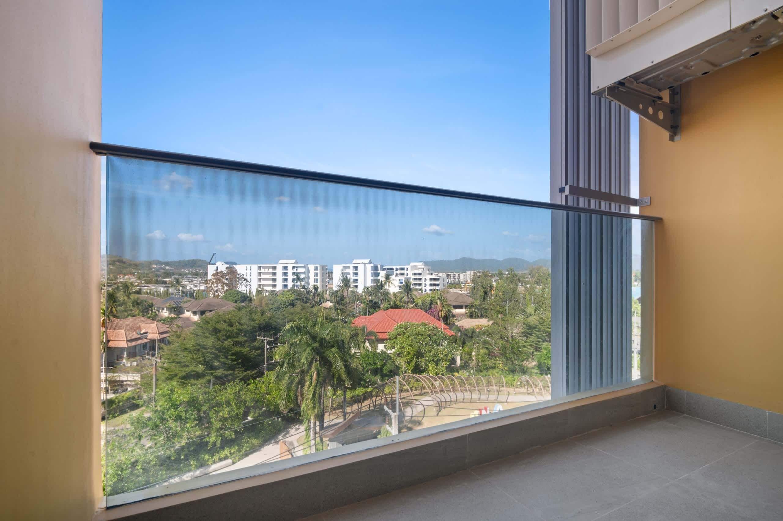 A balcony with a clear view of a residential area, including houses and trees.