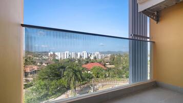 A balcony with a clear view of a residential area, including houses and trees.