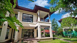 A two-story house with a balcony, a front porch, and a well-maintained lawn. - Laguna Village by Banyan Living (Choeng Thale)