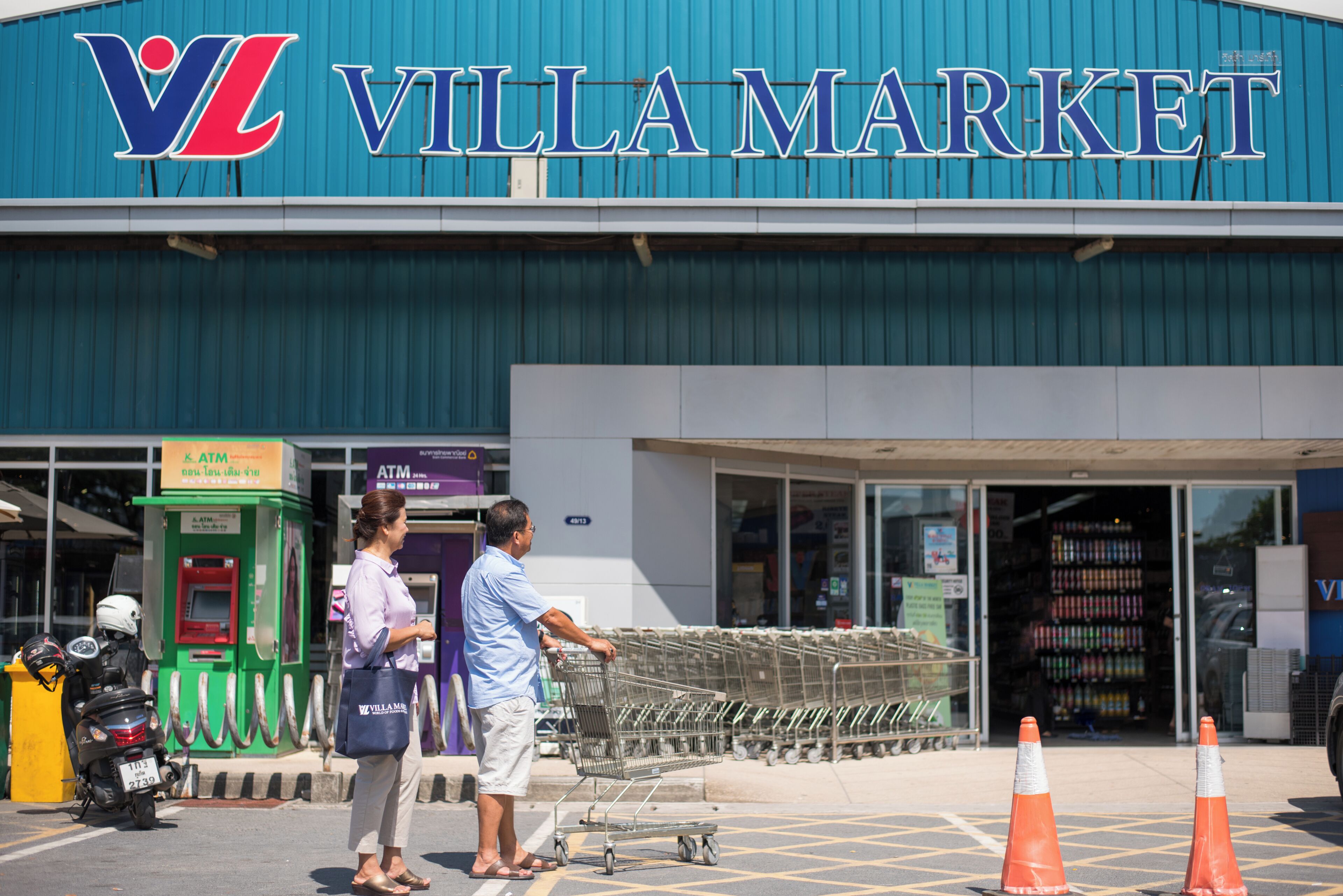 Un chariot de courses se trouve devant un magasin, avec une enseigne au-dessus.