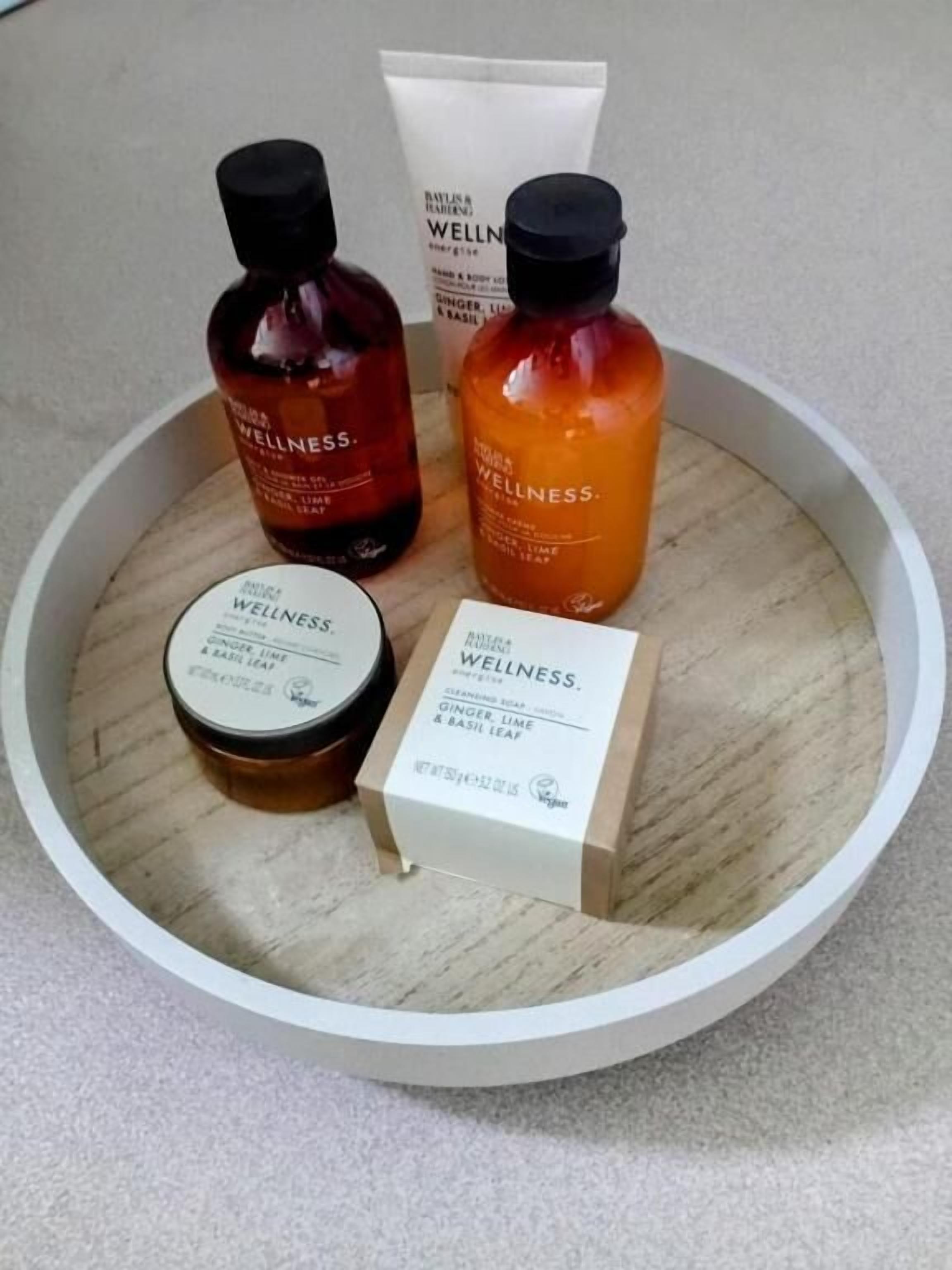 Una bandeja de madera con tres botellas y una caja de productos de bienestar.