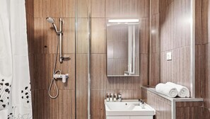 Ein modernes Badezimmer mit Dusche, Waschbecken und Spiegel.