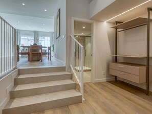A staircase leading to a second floor with a glass shower room, a dining area with a table and chairs, and a built-in wardrobe. - Modern studio near the port - ? guests (Estepona)