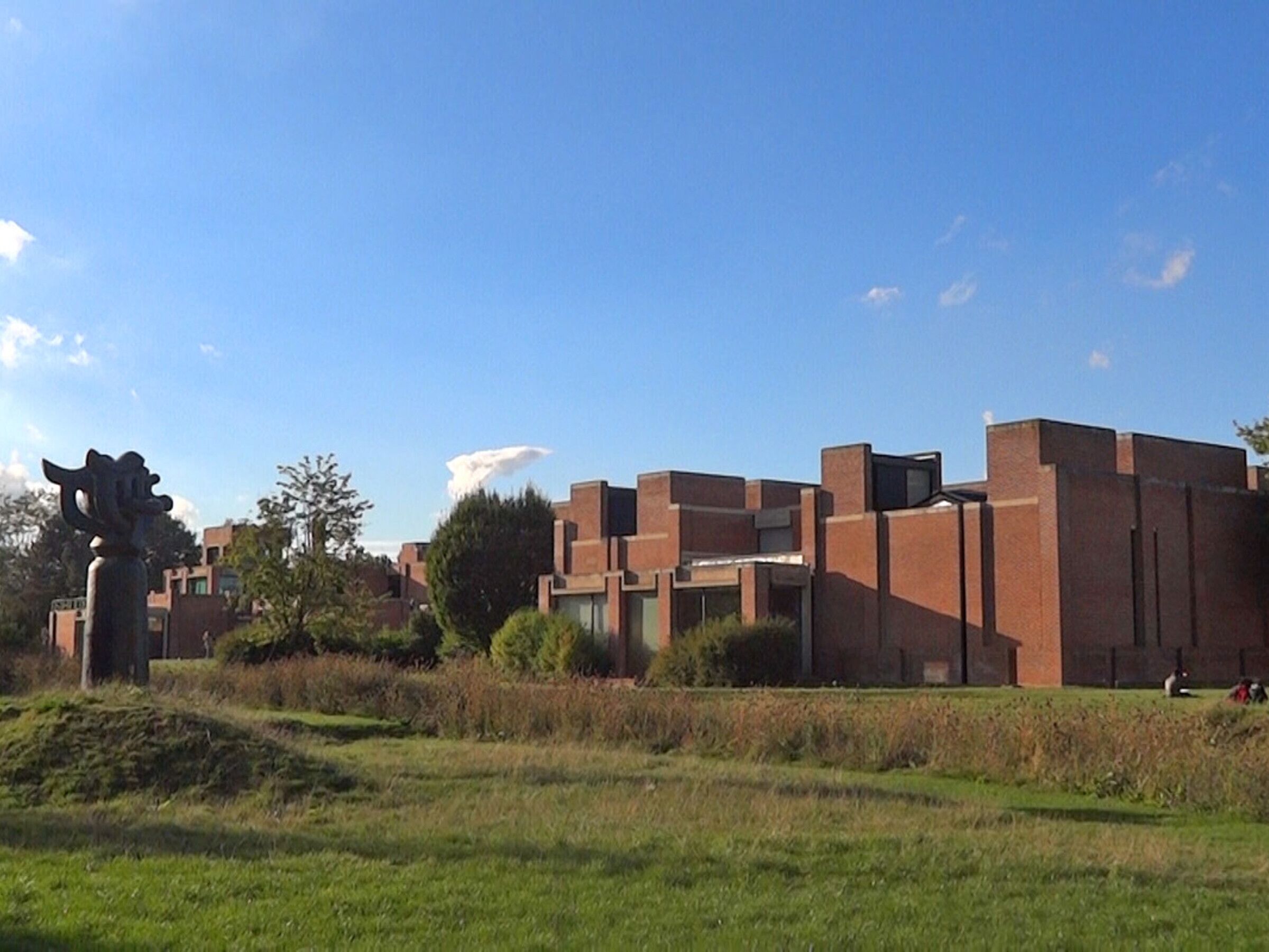 Un bâtiment moderne doté d’un toit plat, de fenêtres rectangulaires et d’une façade en briques.