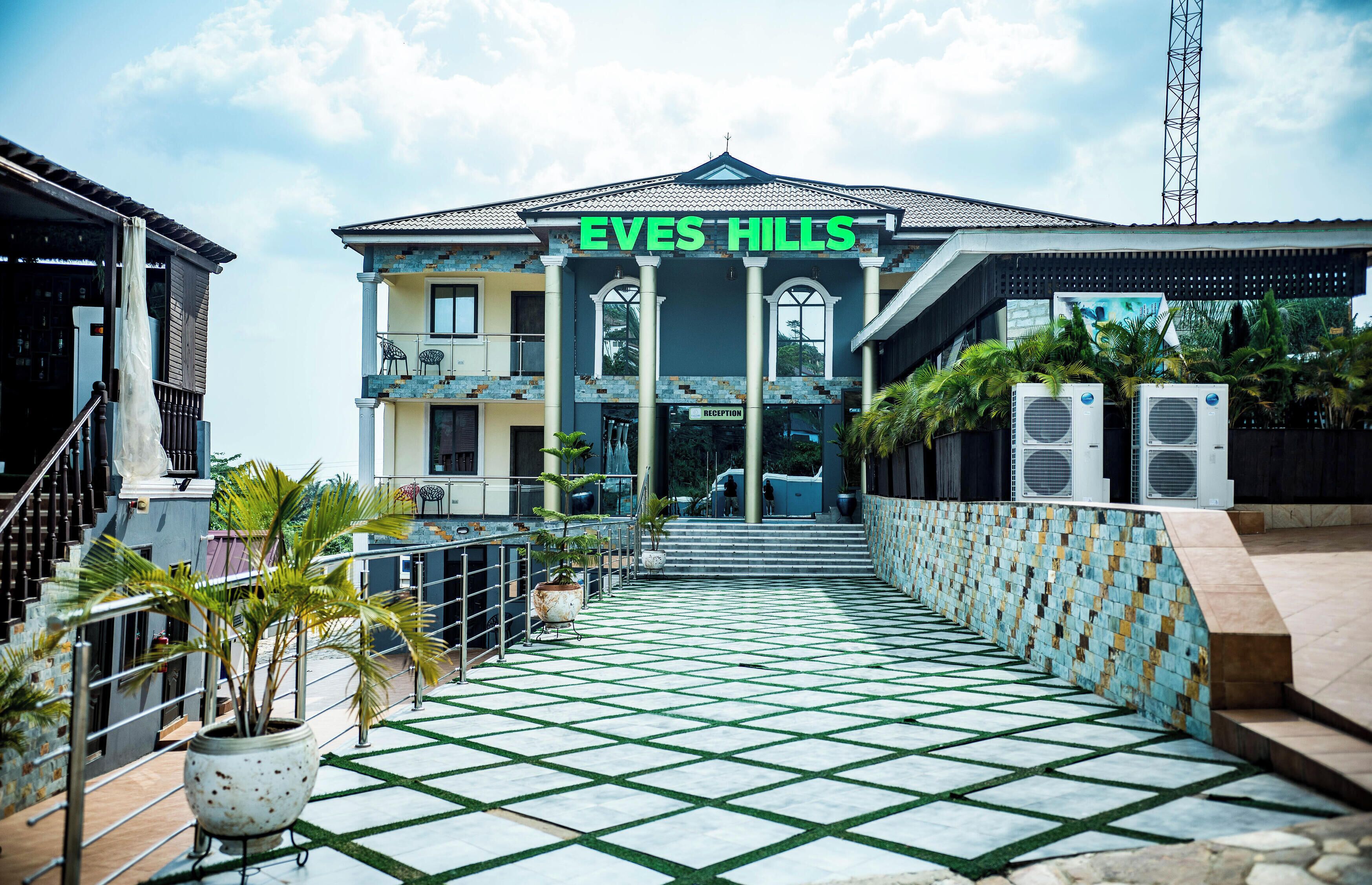 A hotel entrance with a tiled pathway leading to the reception.