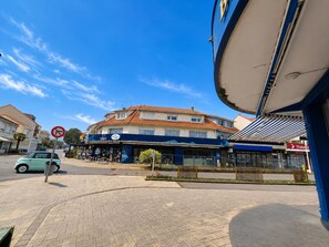Straßenansicht mit einem Geb äude mit blauer Fassade, einem Verbotsschild und einem am Straßenrand geparkten Auto.