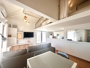 Eine moderne Wohnung mit Essbereich, Küche und Wohnzimmer.