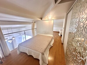 Ein Schlafzimmer mit Bett, einem Balkon und einer Wand mit Dekoration.