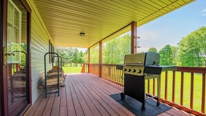 A covered deck with a grill, wooden steps, and a view of a grassy yard. - Glatts - Cabin located in Shunk (Shunk)