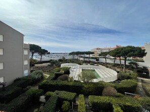 A residential building with a landscaped garden, a pool, and a view of the sea. - Apartment with parking - 6 guests (Cap d'Agde)