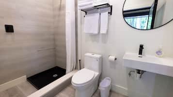 A modern bathroom with a shower, toilet, and sink.