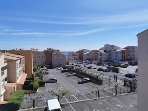 Ein Wohngebiet mit Mehrfamilienhäusern, einem Parkplatz und blauem Himmel.