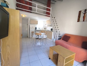 A compact living space with a dining area, kitchenette, and a sofa. - 3-room villa with parking - 7 guests (Cap d'Agde)