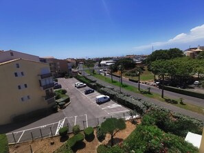 Ein Wohngebiet mit Parkplatz, einem Mehrfamilienhaus und blauem Himmel.