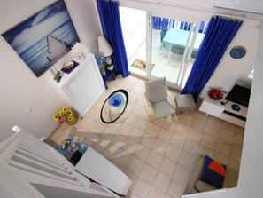 Ein Wohnzimmer mit Essbereich, einer Küche und Blick ins Freie.