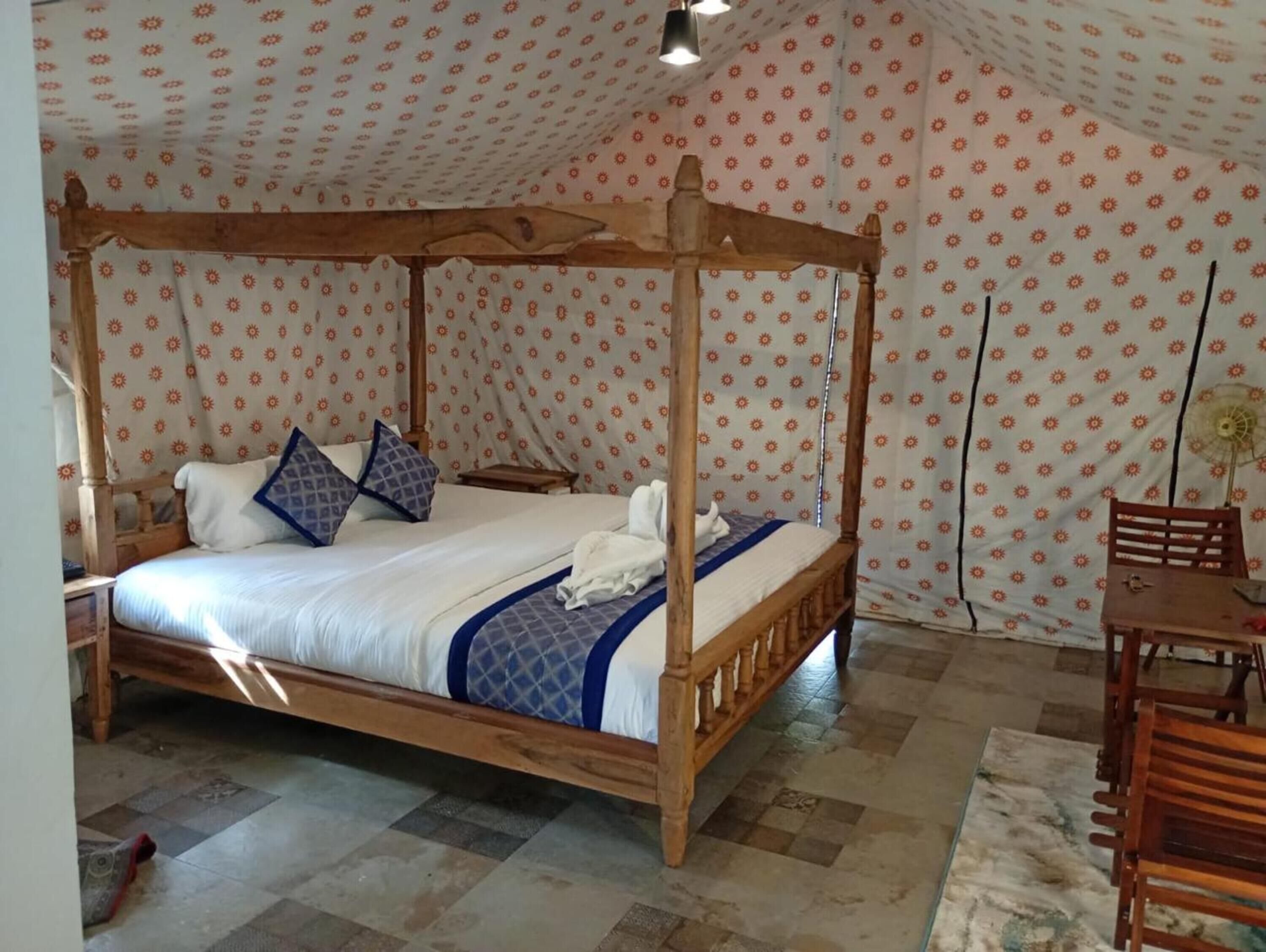 Ein Himmelbett mit Holzgestell, einer gemusterten Decke und einem Schachbrettfußboden.
