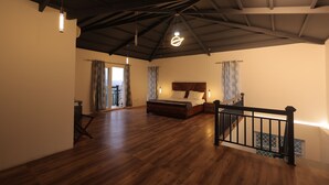 A spacious room with a wooden floor, a bed, a staircase, and a view of the outdoors. - Maktain Glance (Dehradun)