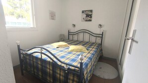 Una camera da letto con un letto, una finestra, una porta e un tappeto rotondo.