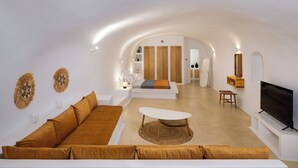 A modern living room with a sofa, a coffee table, and a TV. - Orasis Houses- Luxury Retreats with Pool (Akrotiri)