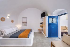 Ein Schlafzimmer mit einem Bett, einer blauen Tür, einem kleinen Tisch und einem Stuhl.