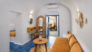 A compact living space with a sofa, a small table, a chair, and a mirror. - Orasis Houses- Luxury Retreats with Pool (Akrotiri)