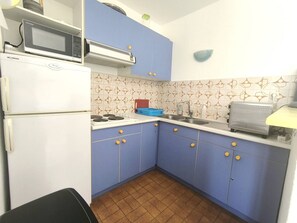 A compact kitchen with a refrigerator, microwave, stove, sink, and toaster. - Apartment with port view - 6 guests (Cap d'Agde)
