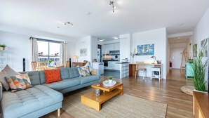 Ein modernes Wohnzimmer mit einer Couch, einem Couchtisch und Blick auf die Stadt.