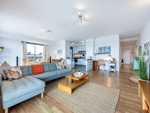 Ein modernes Wohnzimmer mit einer Couch, einem Couchtisch und Blick auf die Stadt.