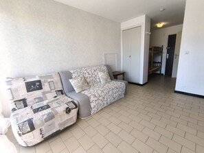 Ein Wohnzimmer mit einer Couch, einer Tür und einem Flur.
