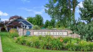 A stone wall with a sign reading 'TRAILSIDE' surrounded by well-maintained landscaping. - Harbor Haven | Hot Tub | Pool Access | Gym | Sauna (South Haven)