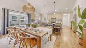 A spacious kitchen with wooden cabinets, a central island, and pendant lighting. - Harbor Haven | Hot Tub | Pool Access | Gym | Sauna (South Haven)