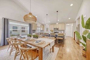 A spacious kitchen with wooden cabinets, a central island, and pendant lighting. - Harbor Haven | Hot Tub | Pool Access | Gym | Sauna (South Haven)