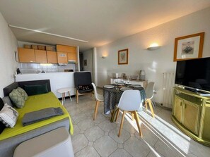 A compact room with a bed, a dining table with chairs, a kitchenette, and a television. - Sea view apartment with parking - 4 guests (Cap d'Agde)