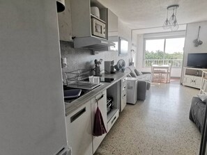 Eine moderne Küche mit Essbereich, einem Fernseher und einem Balkon mit Blick.
