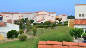 A residential area with multiple two-story houses, a clear sky, and a well-maintained lawn. - Quiet apartment with parking - 6 guests (Cap d'Agde)