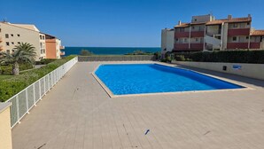 A swimming pool with a view of the sea, surrounded by buildings. - Studio with AC, sea view - 4 guests (Cap d'Agde)