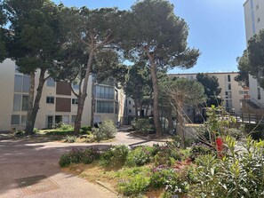 A residential area with apartment buildings, trees, and a pathway. - Apartment sea view, AC and parking - 4 guests (Banyuls-sur-Mer)