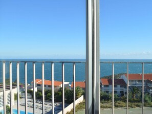 A balcony with a view of the sea and buildings with red roofs. - Apartment sea view, AC and parking - 4 guests (Banyuls-sur-Mer)