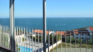 Un balcón con vista al mar y edificios.