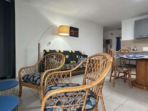 A living area with a sofa, two chairs, a dining table, and a lamp. - Apartment sea view, AC and parking - 4 guests (Banyuls-sur-Mer)