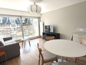 Ein modernes Wohnzimmer mit einer Couch, einem runden Esstisch und einer TV-Bank.