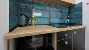 Une cuisine dotée d’un plan de travail en bois, d’un four à micro-ondes et d’un évier.