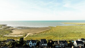 Un paysage côtier avec des maisons, une plage et une vue sur la mer.