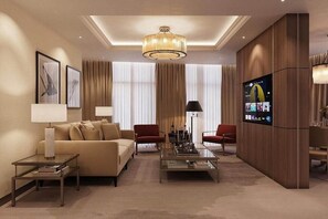 A modern living room with a sofa, two armchairs, a coffee table, a TV, and a chandelier. - Zumma Hotel (Almaty)